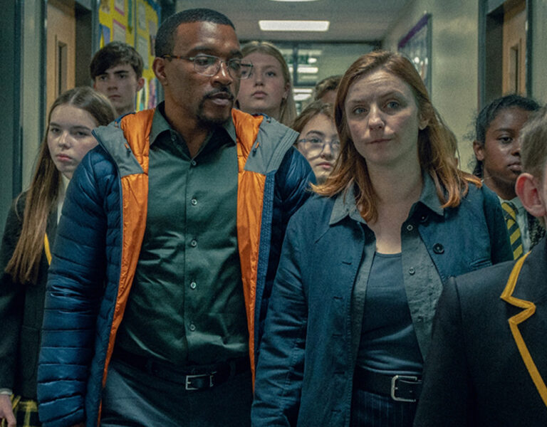 Schoolkids and adults walking down a corridor