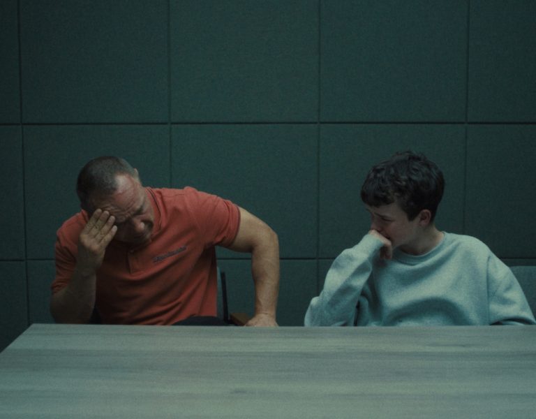 A man and boy sat together crying