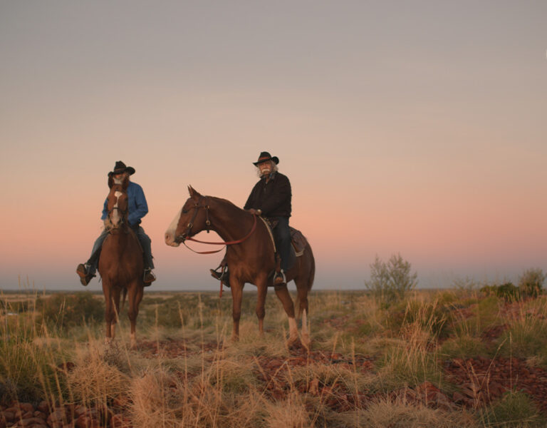 Two men on horseback looking into camera