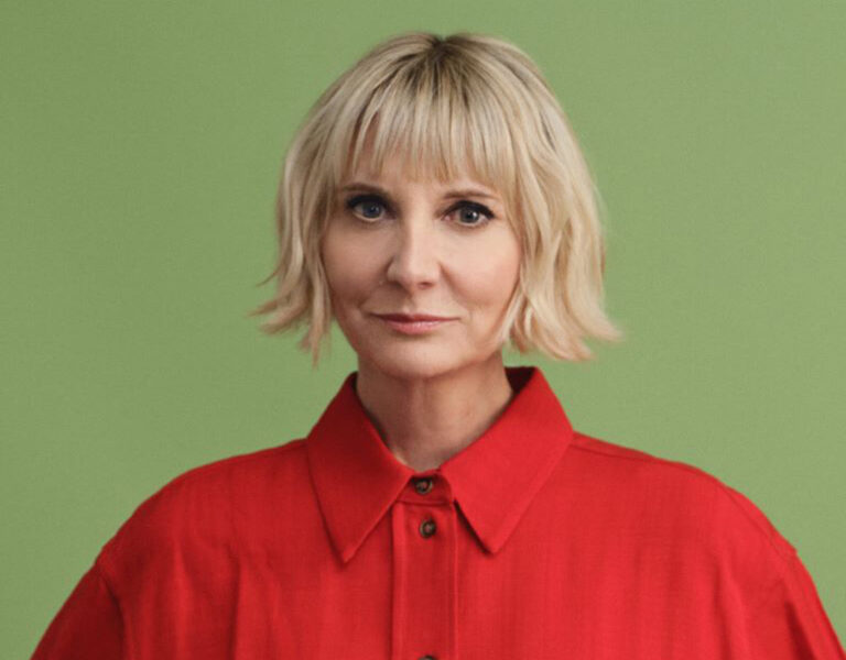 A woman in red looking into camera