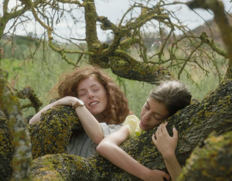 Two girls hugging a tree