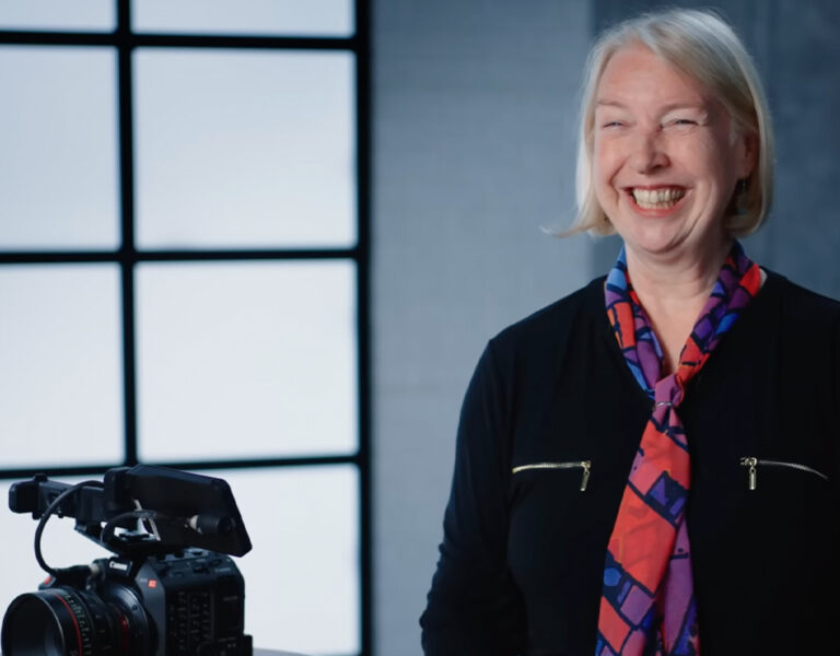Claudia Raschke smiling in front of a camera