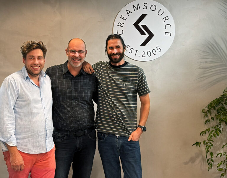 Three people stood together smiling