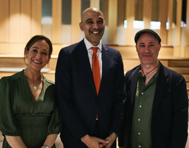 Three people stood together smiling