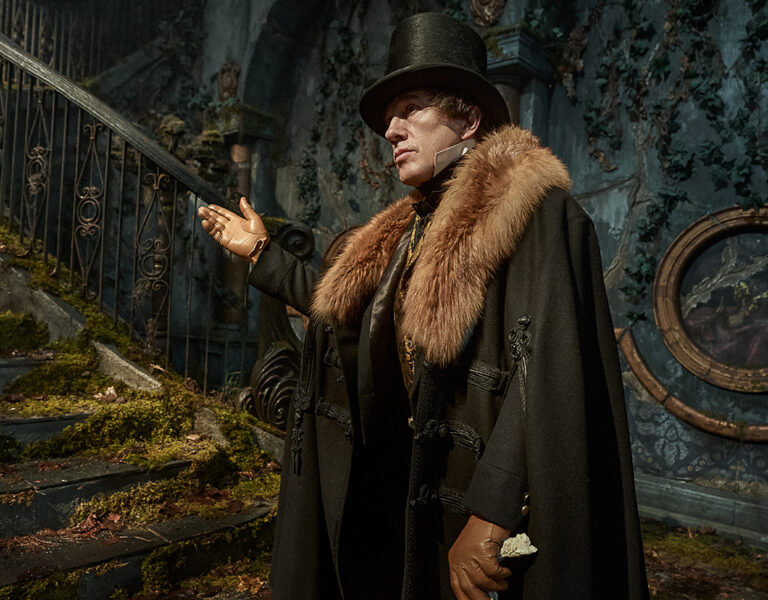 A man standing at the bottom of some stairs pointing up them