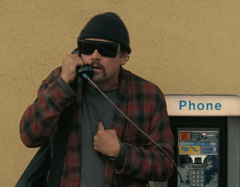 Leonardo Dicaprio on the phone by a phone booth
