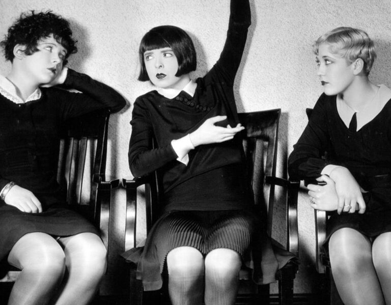 Three women sat in black dresses