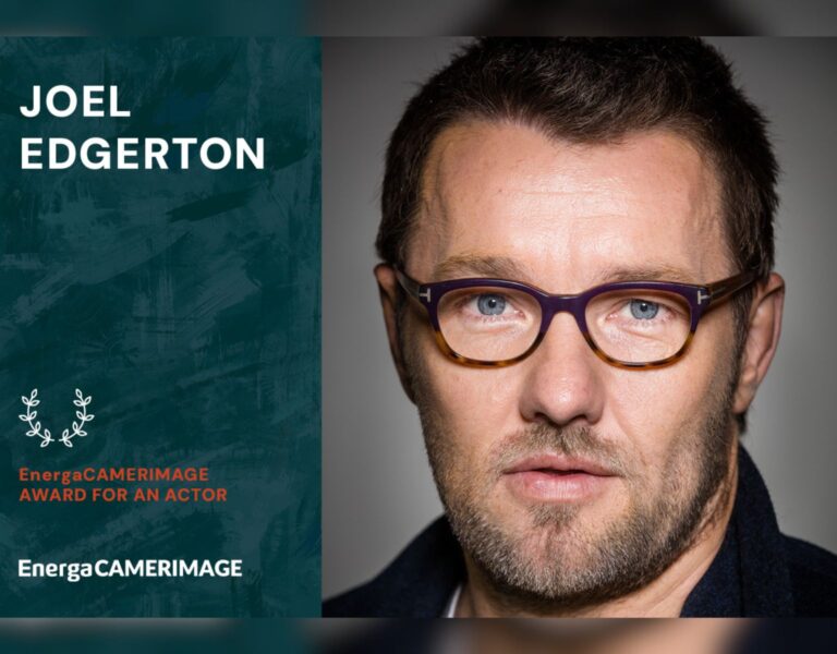 Joel Edgerton in glasses looking into camera