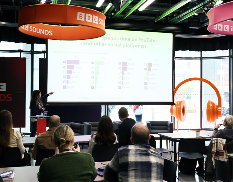 A BBC studio with people watching a presentation