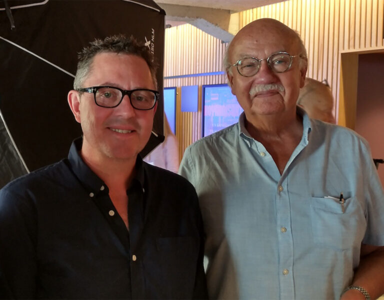 Two men smiling into camera