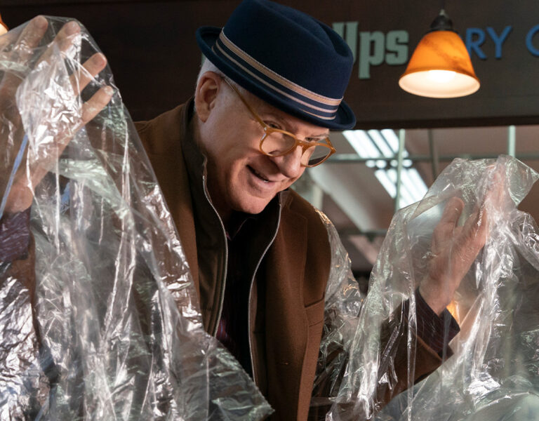 Steve Martin holding dry cleaning