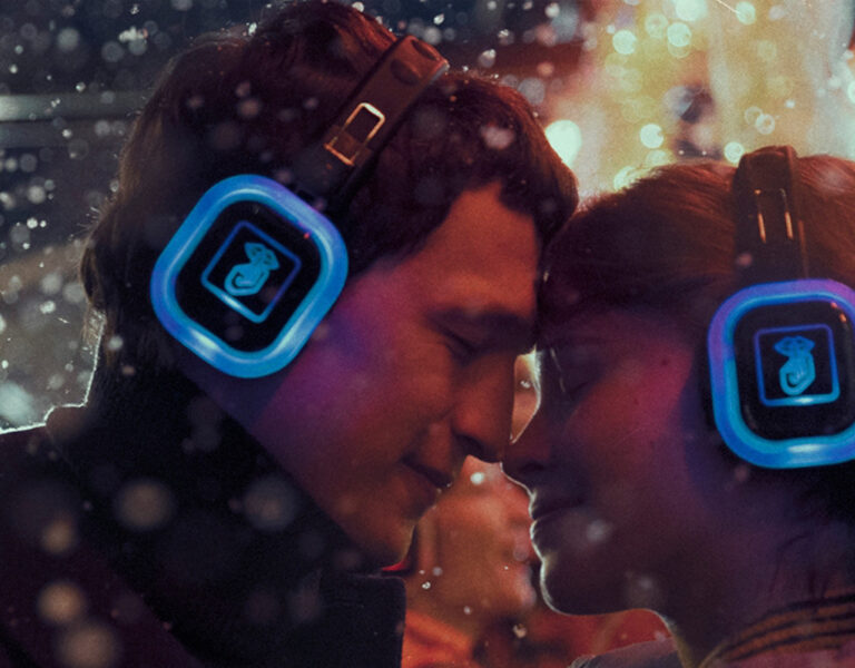 A man and woman in headphones embracing each other