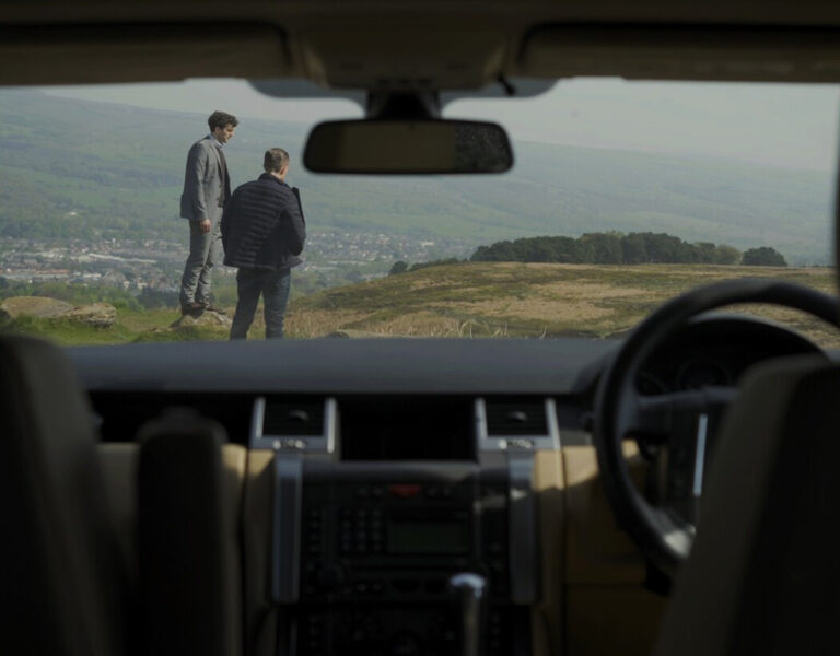 A view through a windshield looking at two men