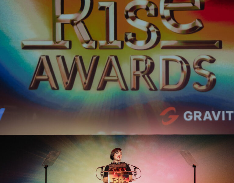 A woman presenting from a lectern