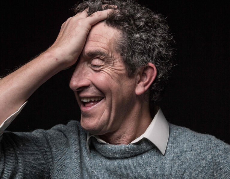 Robbie Ryan smiling with his head in his hand