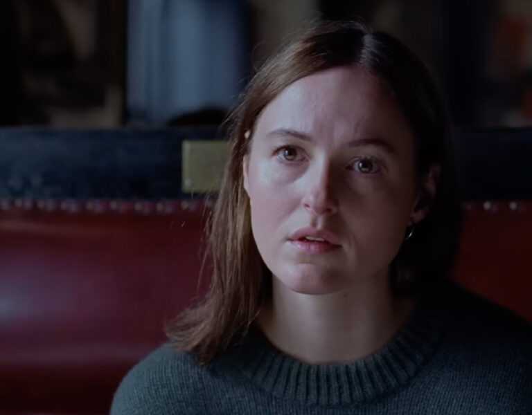 Renate Reinsve looking sad in a cafe