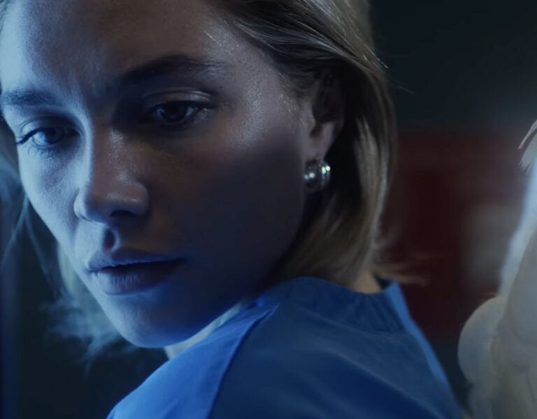 Florence Pugh in a nurse's outfit looking sad